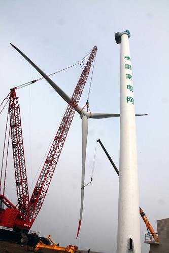 11月7日,工作人员吊装5兆瓦大型永磁直驱型风力发电机.
